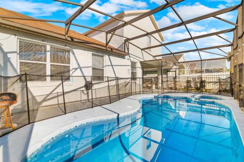 an indoor swimming pool with a glass roof at Beautiful 5BR 4 baths Themed home near Disney and Universal, Private Pool, Gameroom, baby Crib and more in Kissimmee