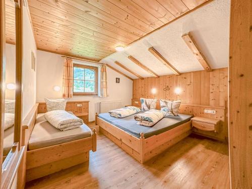 1 Schlafzimmer mit 2 Betten in einem Zimmer mit Holzwänden in der Unterkunft Unterdacheben in Dienten am Hochkönig