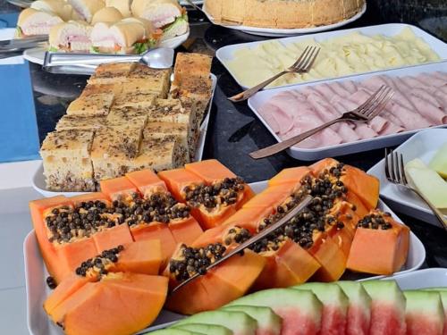 a table topped with different types of food on plates at Pousada Menino do Rio in Búzios