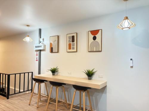 een keuken met een tafel en krukken tegen een muur bij City Pause Hostel in Sathani Bang Su