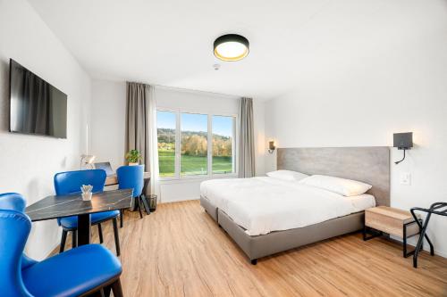 阿旺什Hine Adon Avenches - A2的一间带床、桌椅的酒店房间