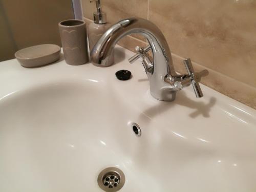 un fregadero blanco con un grifo encima en Apartments Villa ALEN, en Mimice