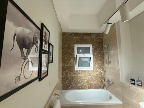 a bathroom with a bath tub and an elephant on the wall at 2BR at The Boulevard Nest Pool - Gym - Café Vibes in New cairo