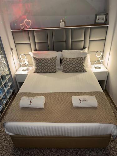 a bedroom with a large bed with two towels on it at Fonte Retreat Premium Suite in Sandim