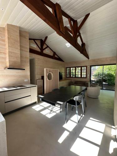 a kitchen with a table and chairs in a room at Le Refuge du Pyla in La Teste-de-Buch