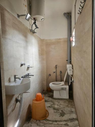 Un baño con lavabo e inodoro en Pandit Devki Nandan Dharamsala & Guest House, en Deoghar