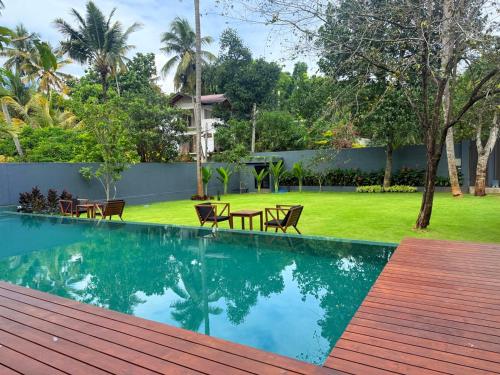 a swimming pool in a backyard with chairs and a yard at Rivora Residence in Kandy