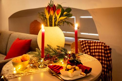 a table with two candles and a vase with flowers at homie stay Dominikus in Würzburg