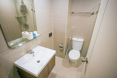 Un baño con inodoro, lavabo y ducha. en Baan Tanwa - MRT Ratchadapisek Exit 1 or 2, en Bangkok