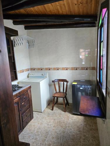 a kitchen with a chair and a washing machine at Hospedaje Casa Arte con Aroma de café in Duitama