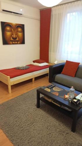a room with a couch and a bed with a face on the wall at Goldapartman Salgótarján in Salgótarján
