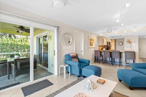 a living room with blue couches and a dining room at Beach Castle Resort #3 in Longboat Key