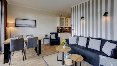 un soggiorno con un divano blu e un tavolo di Strandresidenz Vogelflug Meerblick Fehmarnsund a Fehmarnsund
