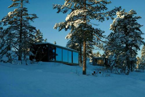 ein Glashaus im Schnee mit Bäumen in der Unterkunft Modern Cabin By The Cross-Country Trails in Svene