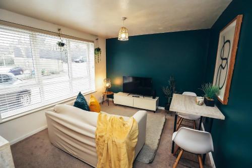 a living room with a white couch and a blue wall at Cosy Apartments for Couples & Working Professionals Free Parking & Smart TV in Derby