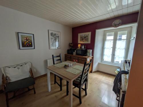 a dining room with a wooden table and chairs at Gourmandise in Coutances