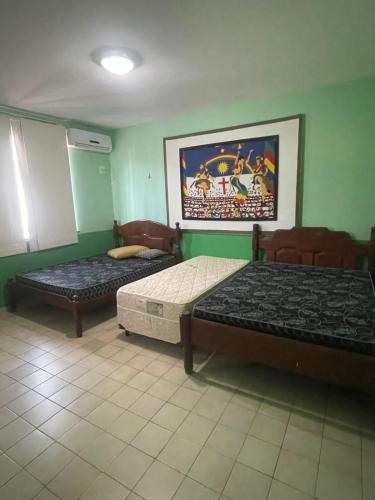 two beds in a room with green walls at Casa espaçosa e completa para grupos em Salinas in Salinópolis