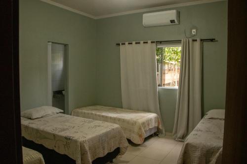 una stanza con due letti e una finestra di Chácara Sabiá a Palmas