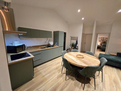 L'entremonts في Steenvoorde: مطبخ وغرفة طعام مع طاولة وكراسي خشبية