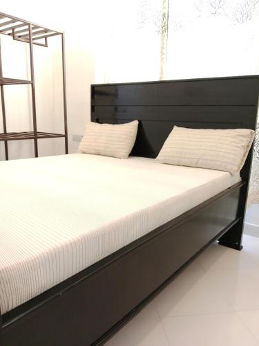 a bed with a black bed frame with two pillows at Hidalgo Explorers Home in Moshi