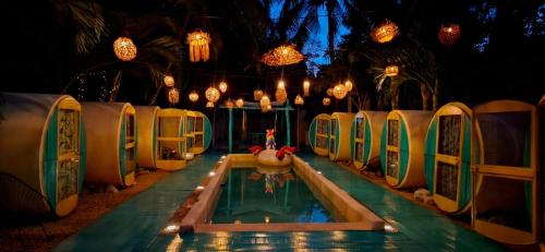 a swimming pool at a resort at night at Kulu Tubohostel Bacalar in Bacalar