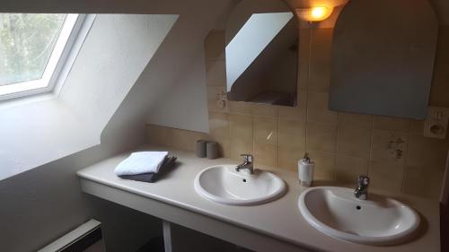 a bathroom with two sinks and a mirror at Chambres D'hôtes d'Evelyne in Sainte Anne d'Auray 