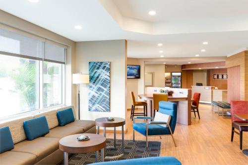 a living room with a couch and tables and chairs at TownePlace Suites by Marriott Louisville North in Jeffersonville