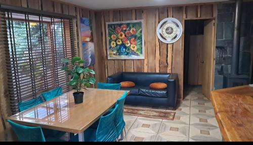 a living room with a table and a couch at Cabañas Torres Del Bosque in Pucón