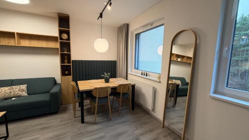 un soggiorno con un tavolo, un divano e uno specchio di Kahlo Apartment a Cesky Krumlov