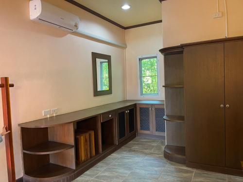 een kamer met een bureau en boekenplanken in een kamer bij Stay here at pai in Pai