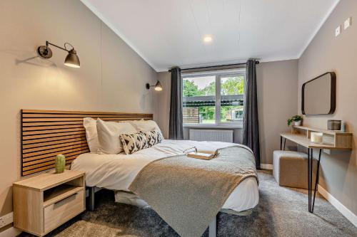 a bedroom with a bed and a window at Landal Bryn Morfydd in Llanrhaiadr