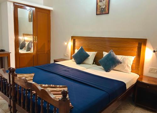 Un dormitorio con una cama grande con almohadas azules y blancas. en Hotel Sea View Palace - the beach hotel, en Kovalam