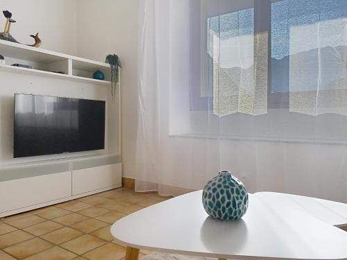 a vase sitting on a table in a room with a tv at Les Cerisiers in Saint-Étienne-de-Crossey