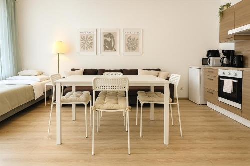 una sala da pranzo bianca con tavolo e sedie di Airport-Messe Apartments a Dusseldorf