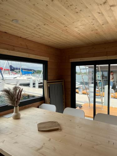 une salle à manger en bois avec une table et des chaises en bois dans l'établissement Bateau Lac du Der - Chantecoq - Navigation, 