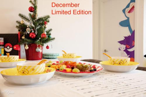 a table with bowls of fruit and a christmas tree at Trainer's Cozy Home - Town of Beginnings マサラタウンのトレーナーのおうち in Melbourne