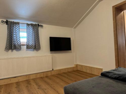 MichaelerbergSki und Wander Ferienhäuser Galsterberg-Blick Pruggern - Schladming-Dachstein的卧室配有壁挂式平面电视。