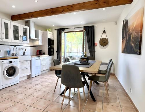 eine Küche mit Esstisch und Stühlen in der Unterkunft Gîte Bijou - Les Petites Écuries in Marseillette