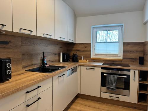 MichaelerbergSki und Wander Ferienhäuser Galsterberg-Blick Pruggern - Schladming-Dachstein的厨房配有白色橱柜、水槽和窗户