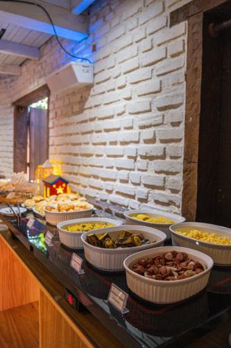 a buffet with many bowls of food on a table at Cores do Arraial Residence Hotel in Arraial d'Ajuda