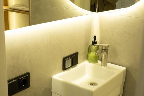 a bathroom sink with a soap dispenser on it at Central City Vibes Apartment in Chişinău