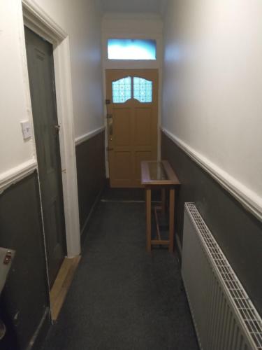 a hallway with a door and a table in front of it at Honor in London