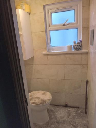a bathroom with a toilet and a window at Honor in London