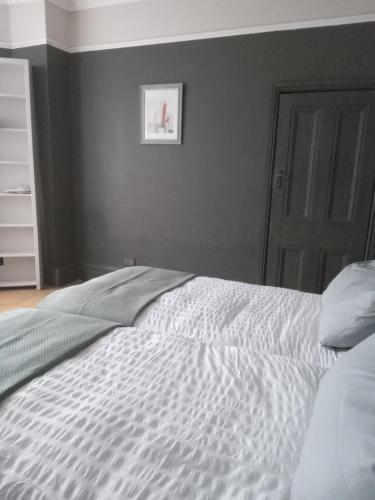 a bedroom with a white bed with a gray wall at Honor in London