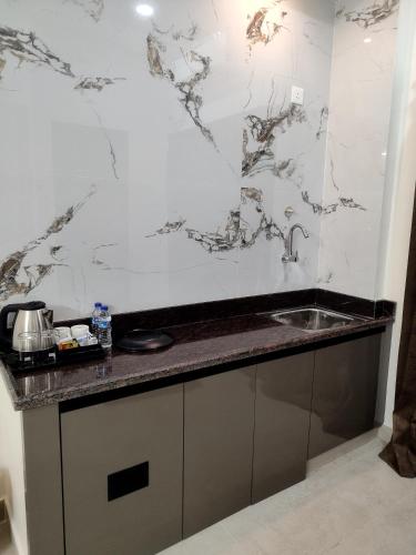 a kitchen with a sink and a marble wall at Mount Bliss Stay in Tiruvannāmalai