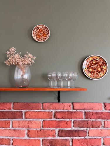 GałkowoPrzystanek Gałkowo的一面砖墙，架子上摆放着盘子和玻璃杯。