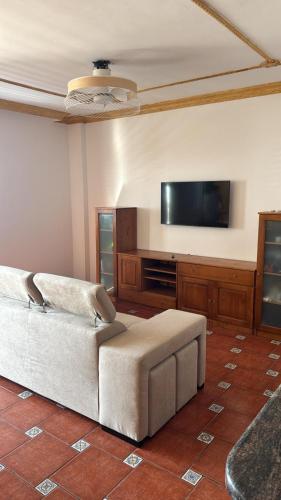 ein Wohnzimmer mit Couch und Flachbildfernseher in der Unterkunft El Pescador El Pris, by Nivariahost in El Pris