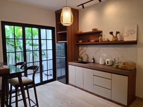 a kitchen with a counter and a table and a window at Enjoy and relax living villa style residence in Batam Center