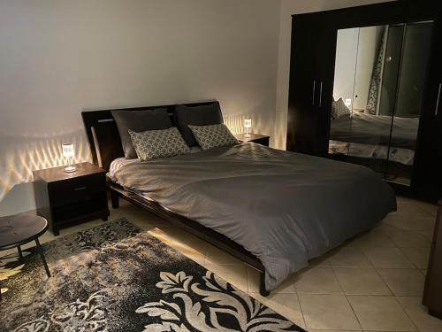 una camera da letto con un letto grande e uno specchio di Cosy 2 bedroom appartment a La Corniche