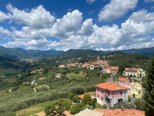 a town on a hill with mountains in the background at Rosa Di Mare Guest House in Borgio Verezzi